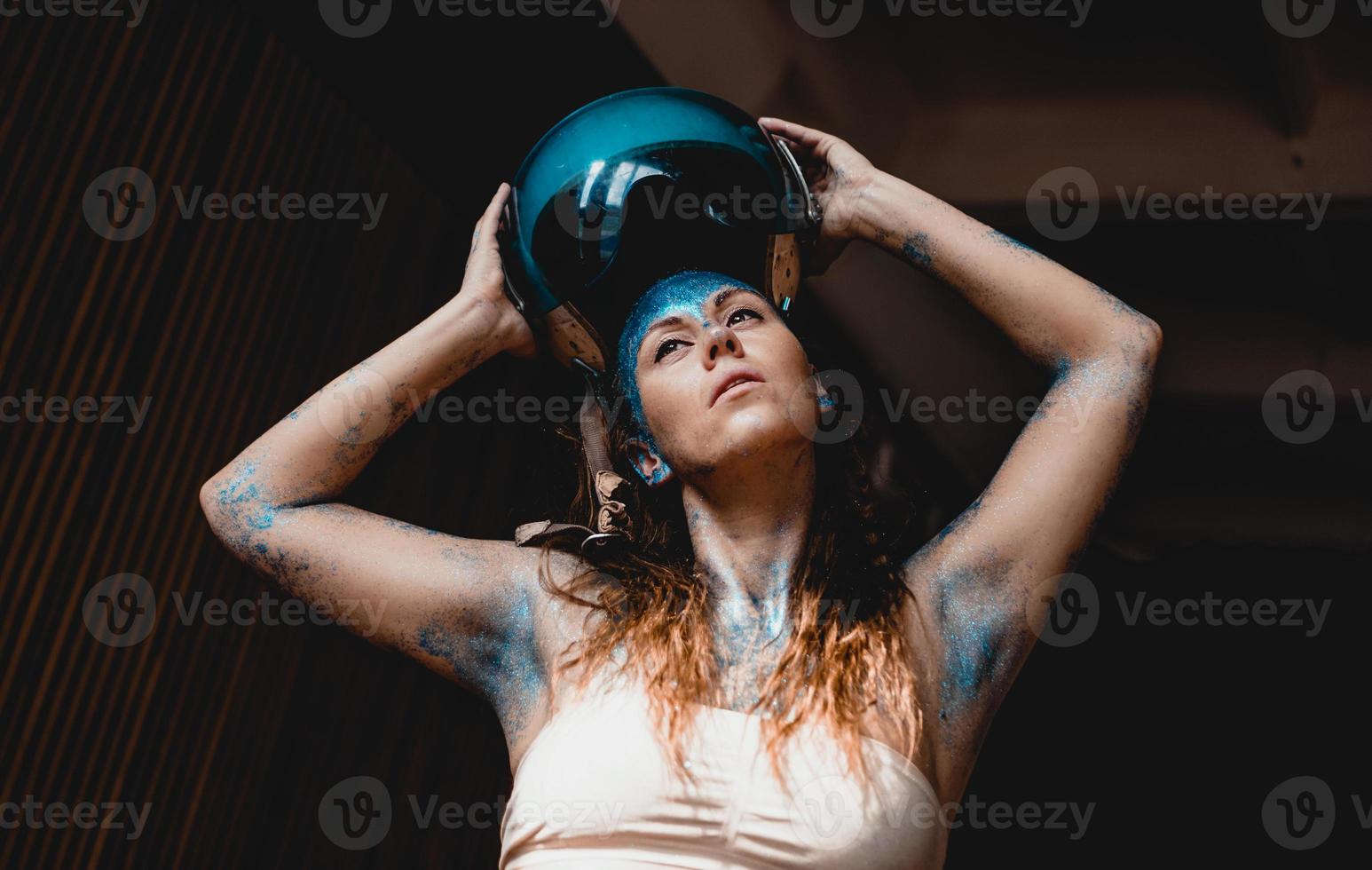 le motard a mis un casque. femme avec des étincelles bleues sur son visage. photo