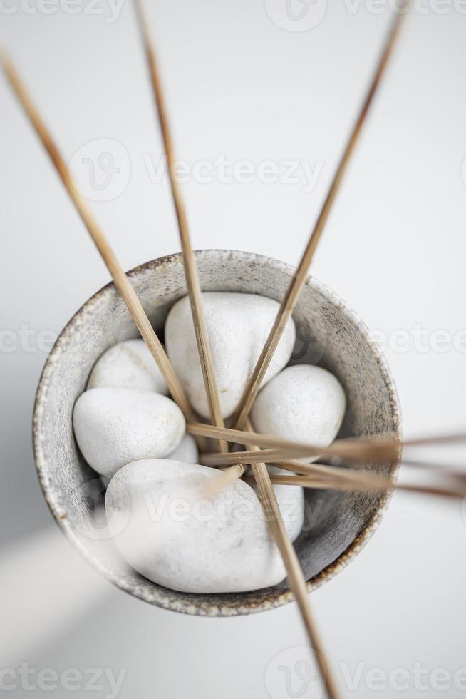 décoration pierres blanches et bâtons de paille dans un pot photo