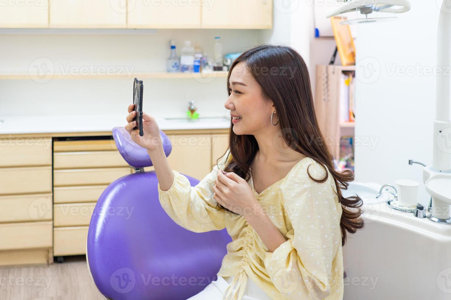 patient utilisant un miroir pour regarder les dents photo
