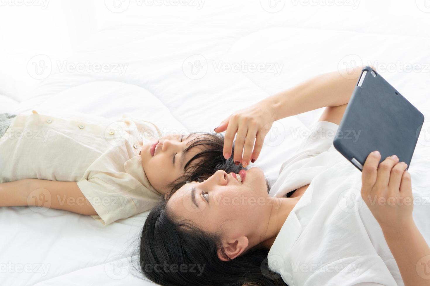 mère et fille allongée sur un lit photo