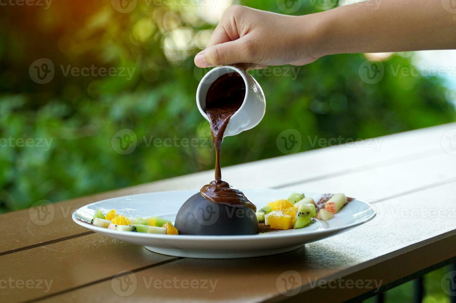 Chocolat dôme par couvrant biscuits. fruit et la glace crème de votre choix. Comment à manger, mettre chaud Chocolat sur le dôme jusqu'à ce que il fond et tu es prêt à prendre plaisir le riches la glace crème et Chocolat treillis. photo