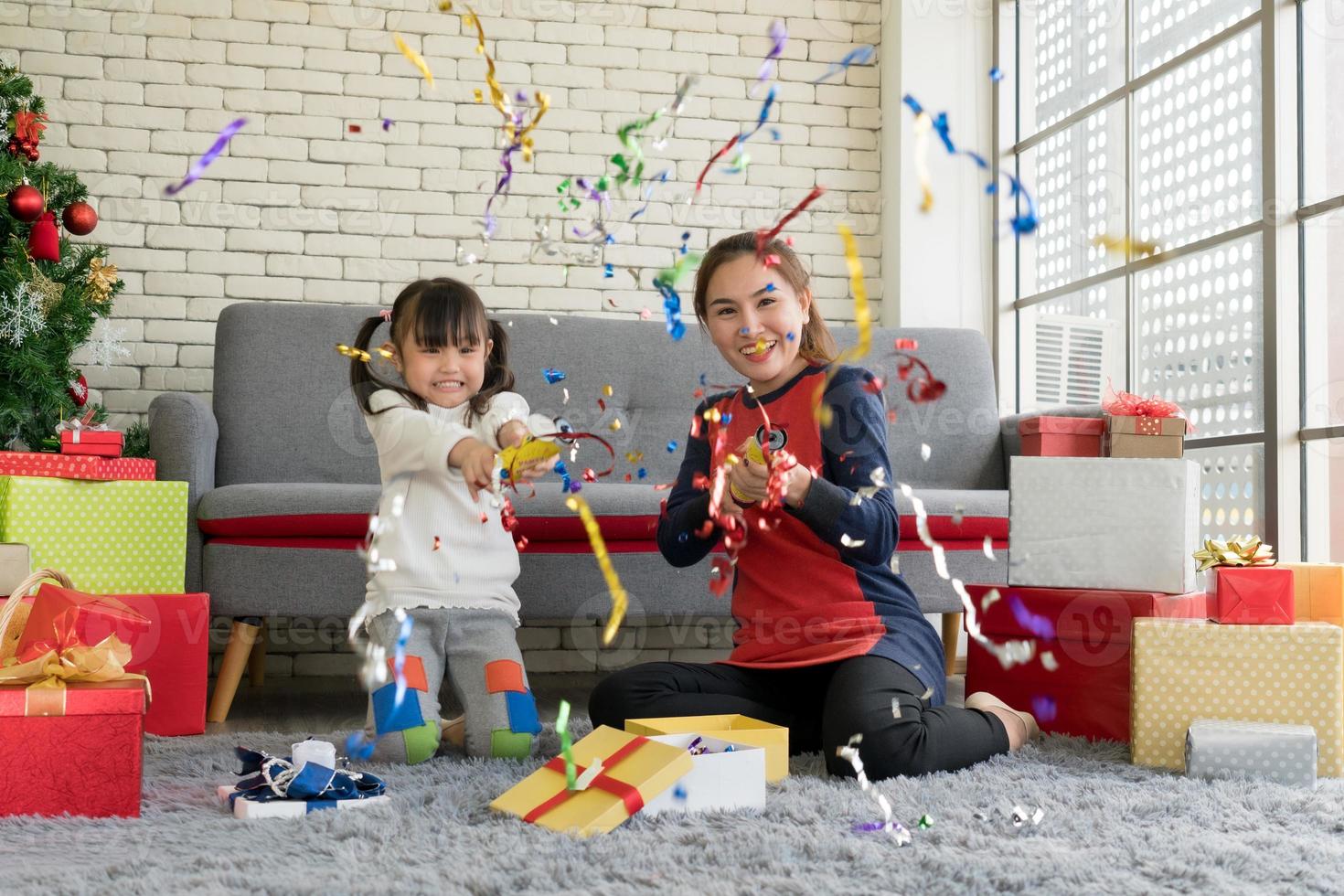 mère et enfant célébrant noël avec des confettis à la maison photo