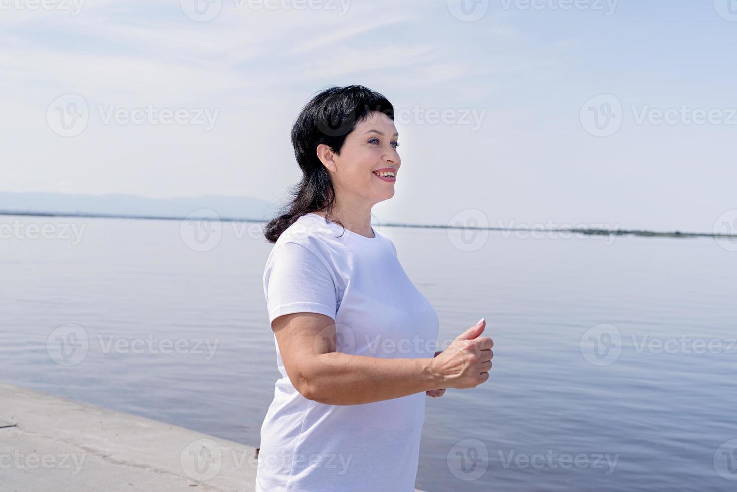 femme senior active jogging près de la rivière photo