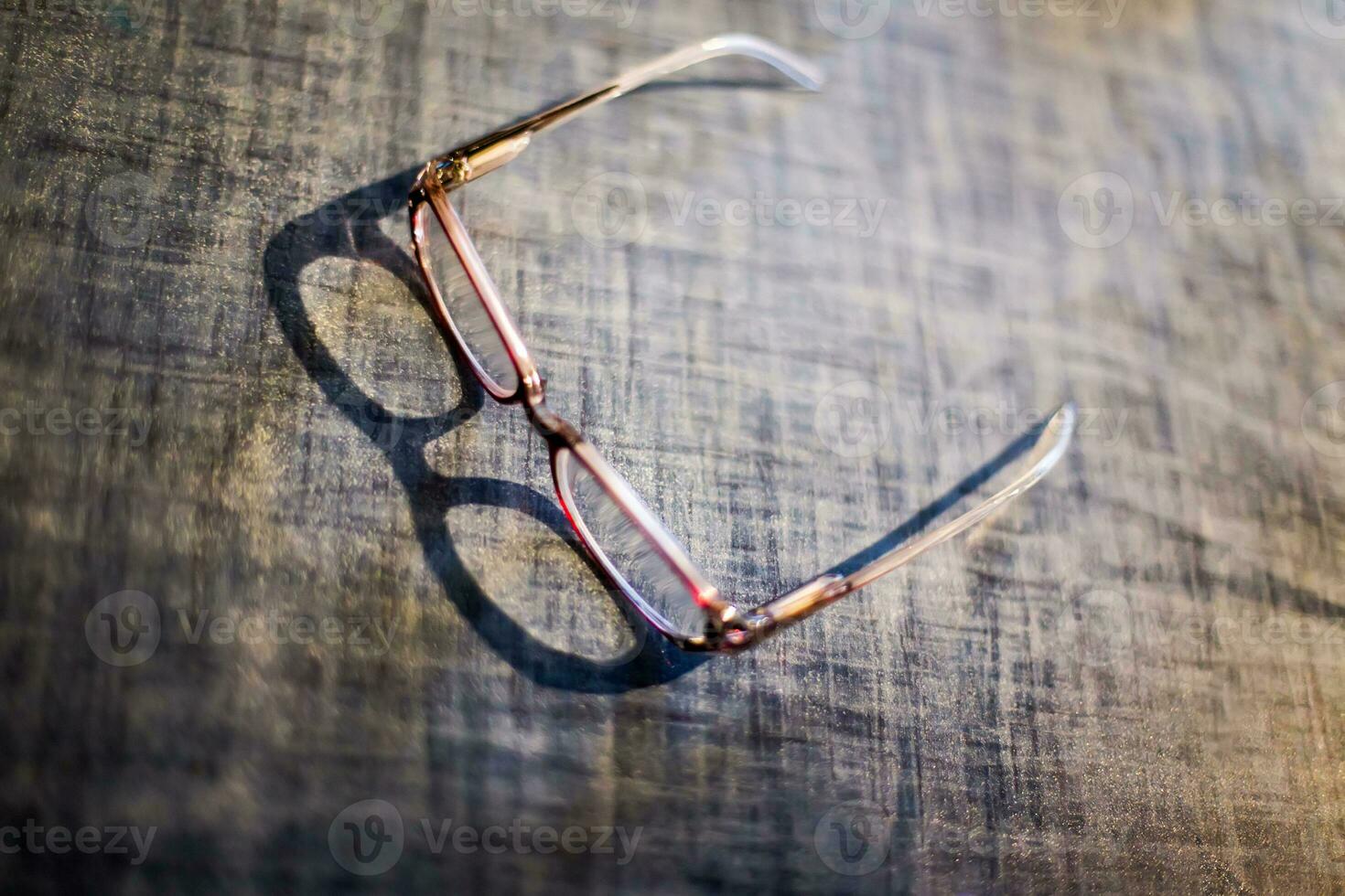 des lunettes mensonge sur le cuisine tableau. le ombre de le des lunettes sur le tableau. vieux Pour des hommes lunettes. doux se concentrer. film grain. brouillé défocalisé photo