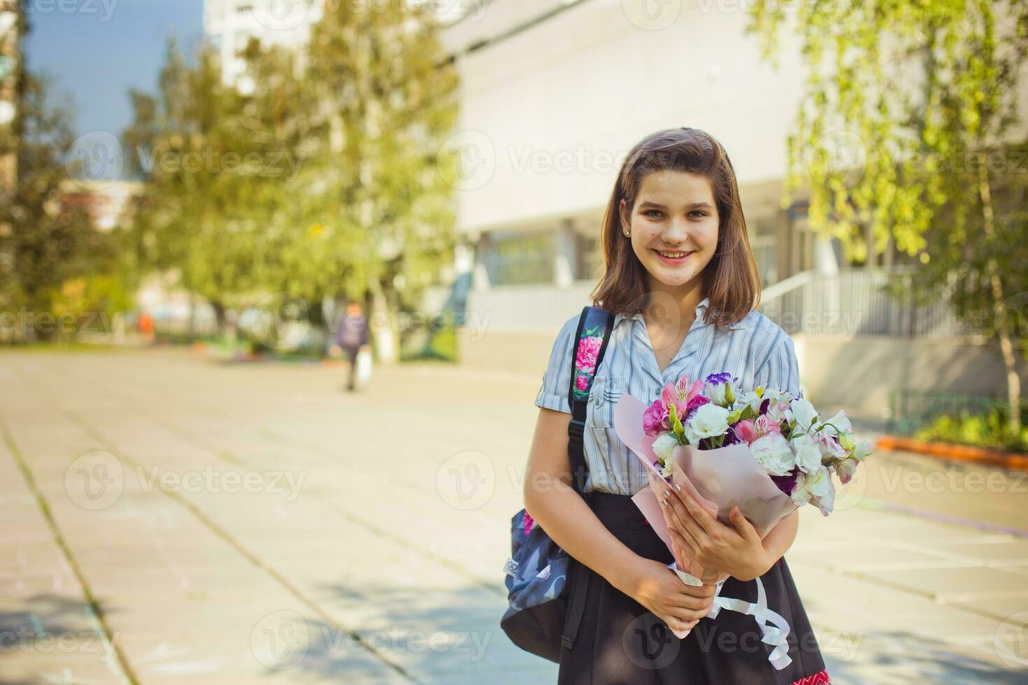 fille avec une bouquet de fleurs près le école. le premier de septembre. le premier professeur. content enfant. photo