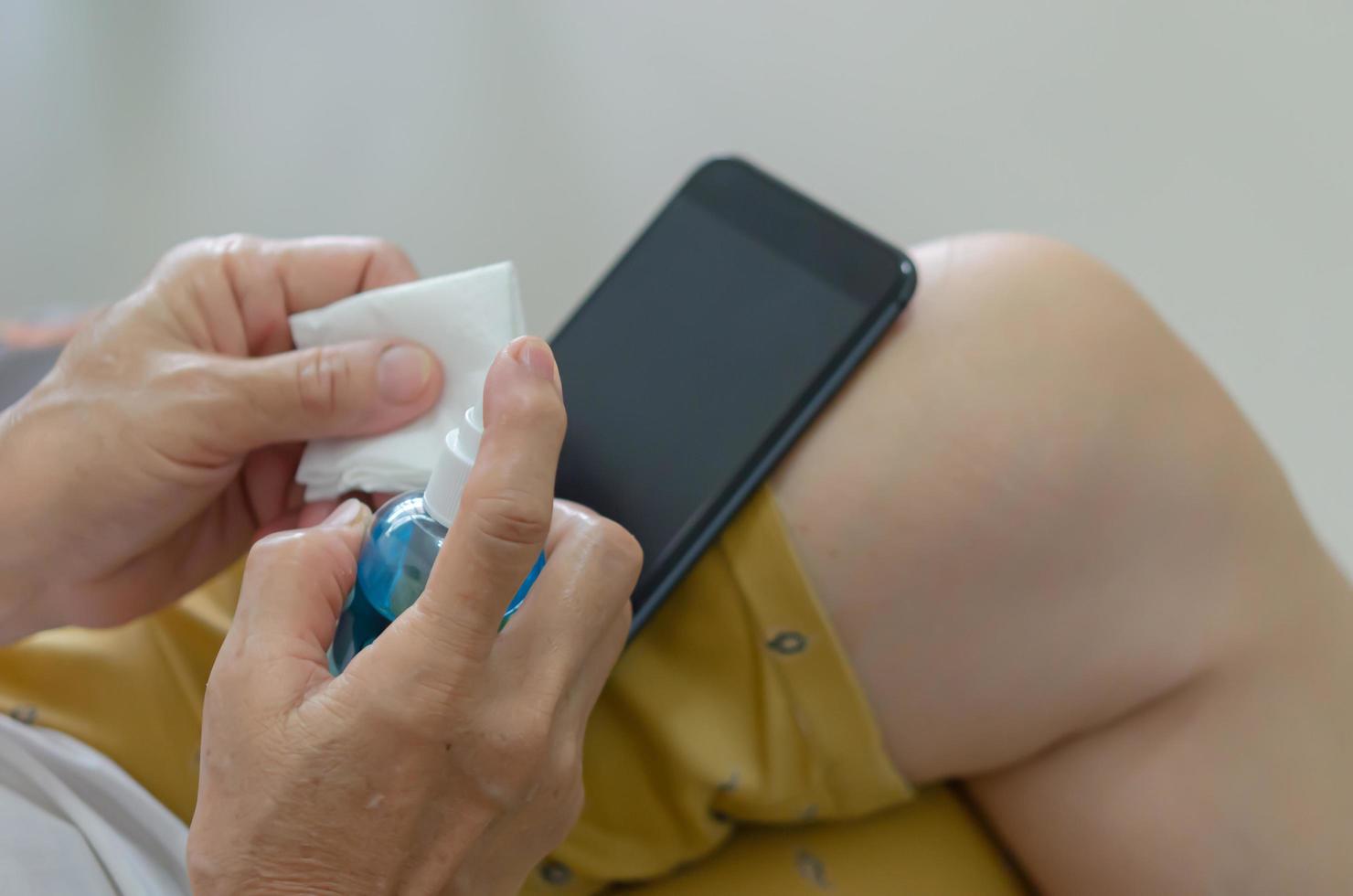 nettoyez votre téléphone portable avec de l'alcool pour éviter les germes. photo