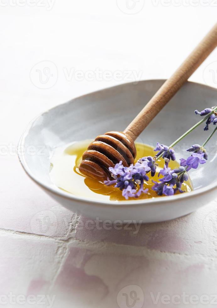 bol avec du miel et des fleurs de lavande fraîche photo