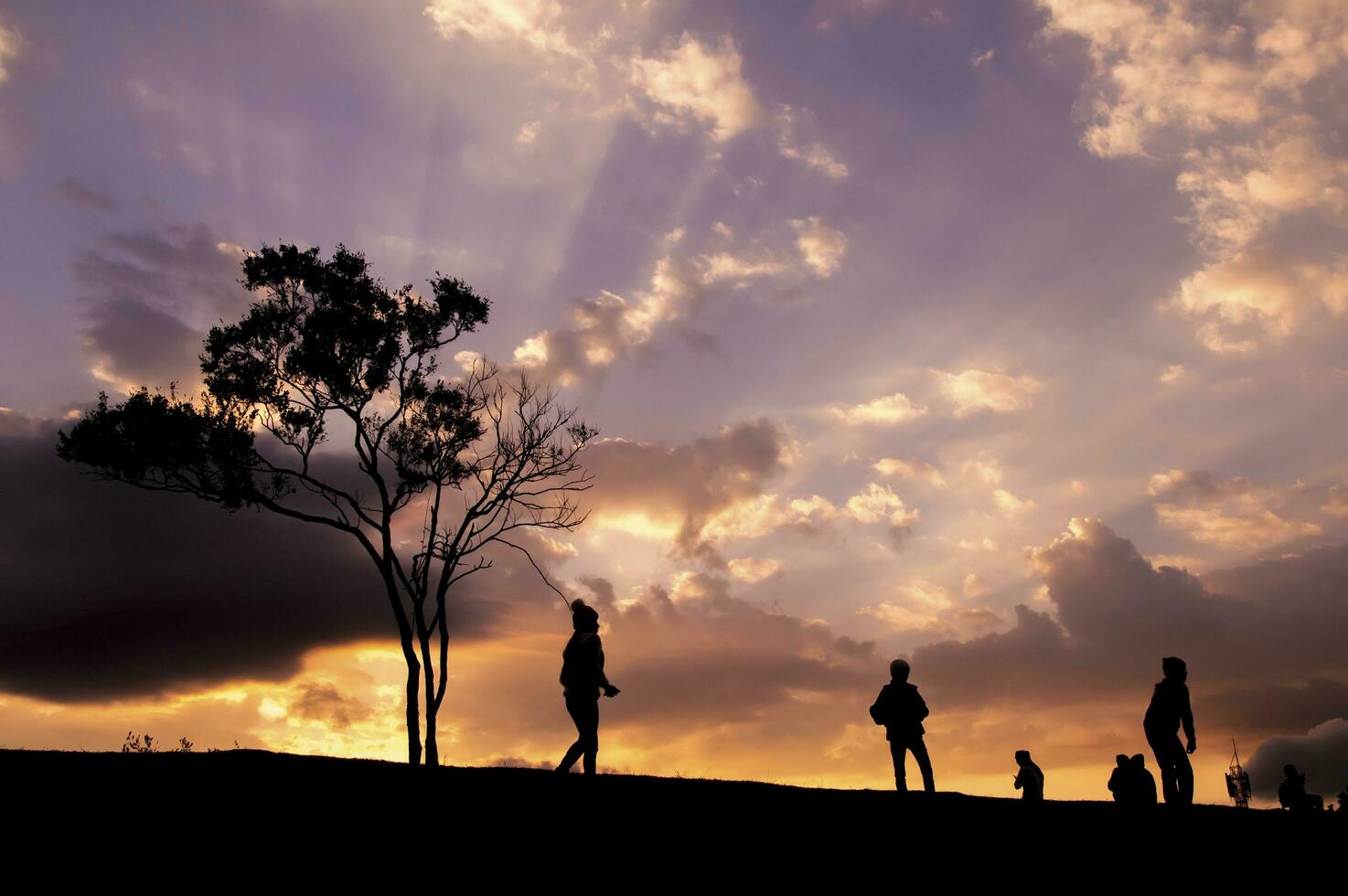 silhouette de gens en marchant sur le colline avec spectaculaire ciel photo