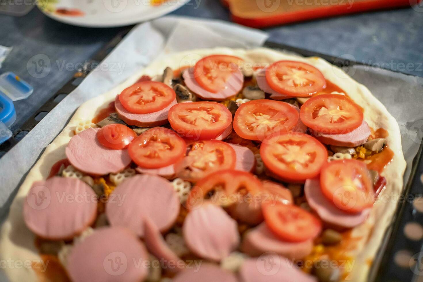 fait maison Pizza avec saucisse et Frais tomates. en train de préparer nourriture à Accueil de Facile nourriture. photo