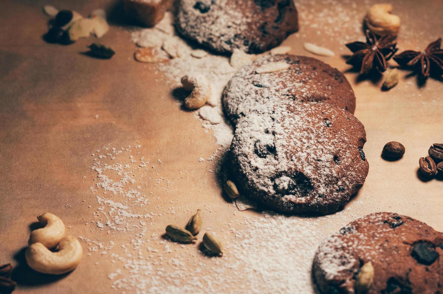 vue de dessus de biscuits au chocolat croquants avec noix, cardamome et anis étoilé sur fond de parchemin texturé, fariné. espace vide pour votre texte et votre design photo