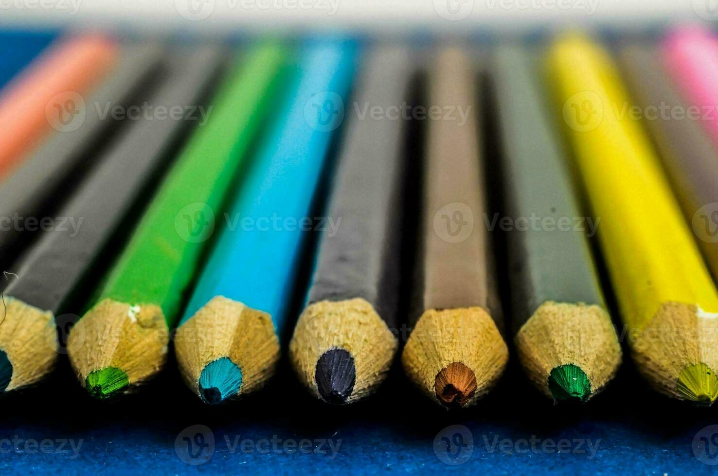 une rangée de coloré des crayons sur une bleu surface photo