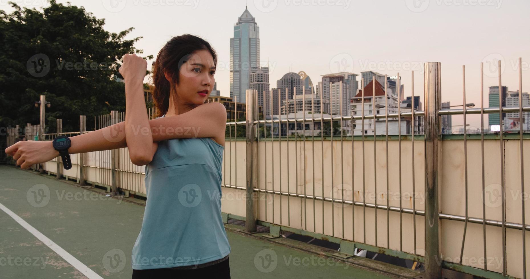 athlète asiatique exerce des exercices d'étirement en milieu urbain. photo