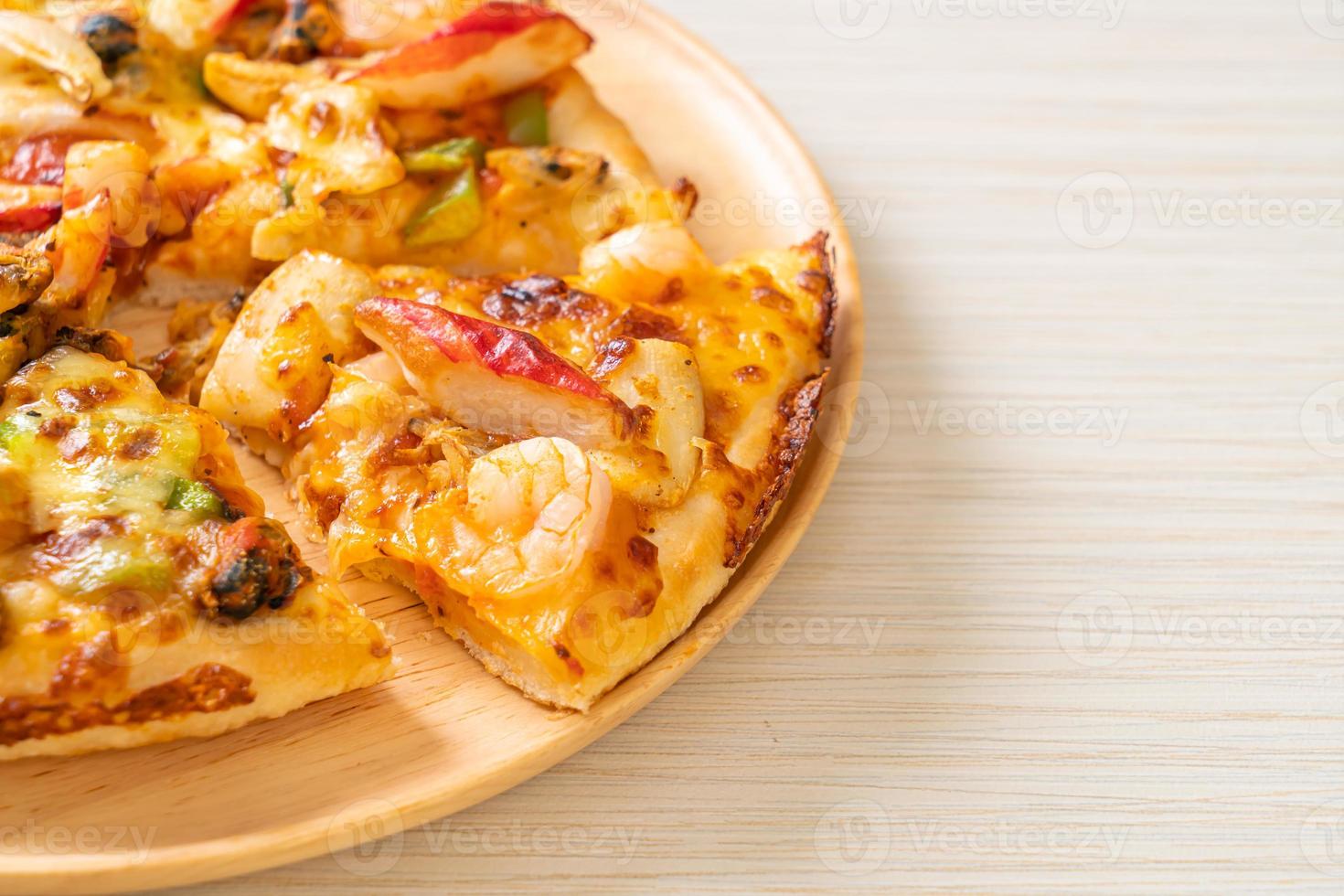 Pizza aux fruits de mer sur plateau en bois photo