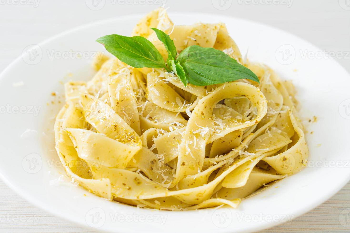 pâtes fettuccine au pesto avec du parmesan sur le dessus photo