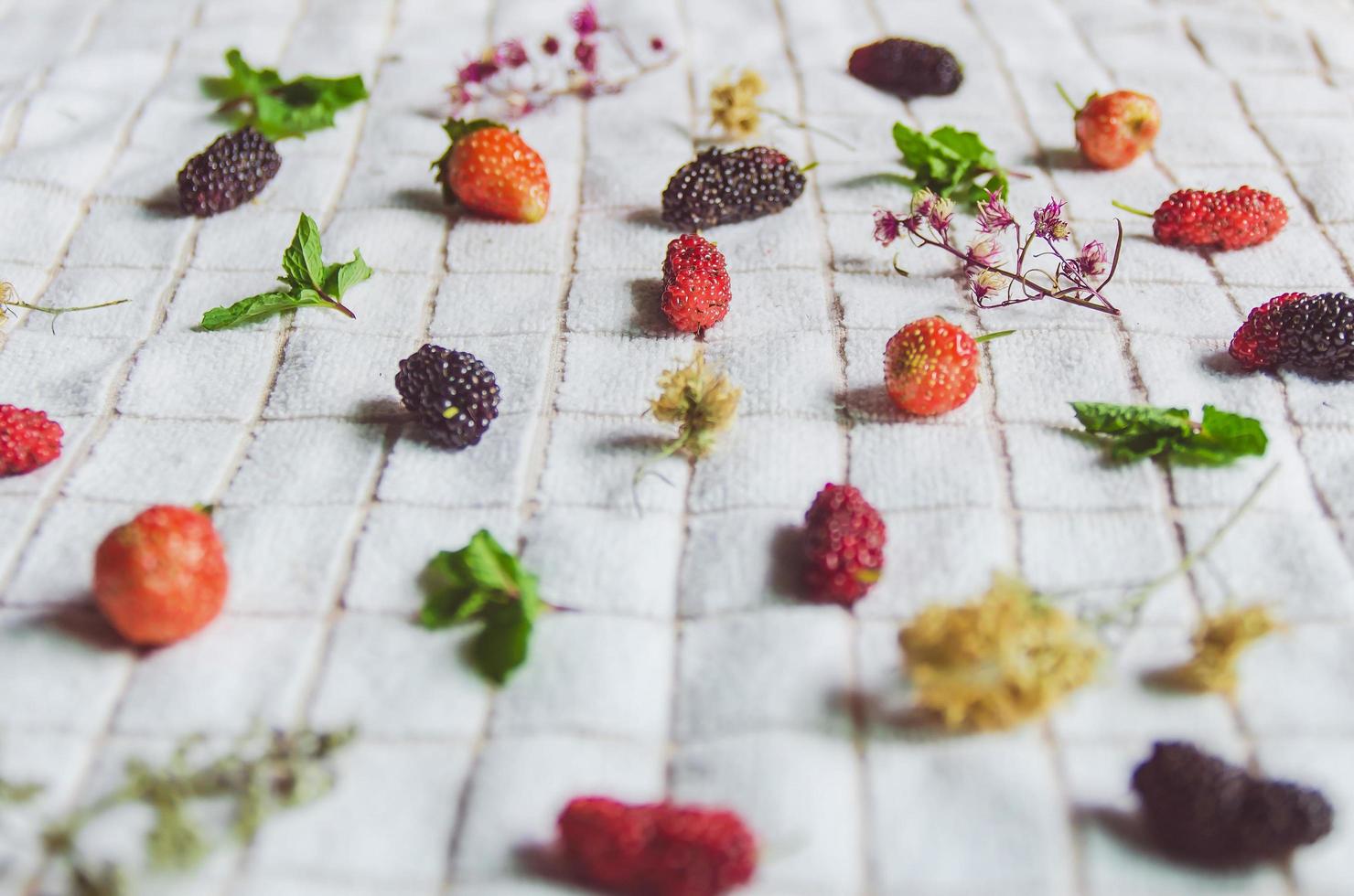 mûre et fraise, baies fraîches sur tissu blanc. photo