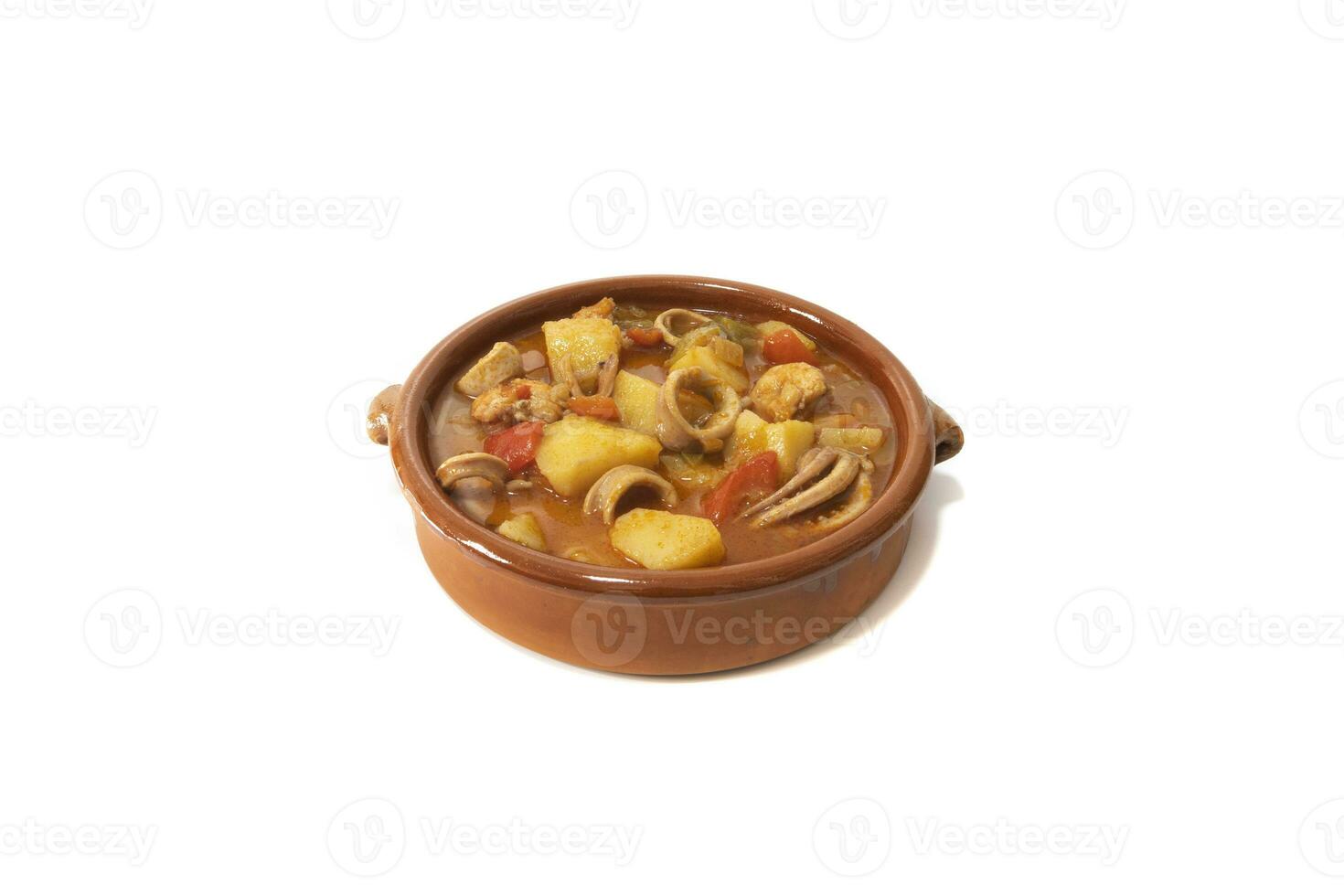 une Patate Ragoût avec calamars, servi dans une argile bol, isolé sur une blanc Contexte. Espagnol nourriture concept. photo