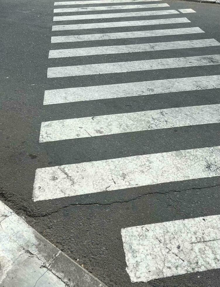 rugueux blanc zèbre traverser marcher rayures pour piéton isolé sur asphalte béton Publique route Extérieur. verticale la photographie rapport avec non gens ou la personne dans vue. photo