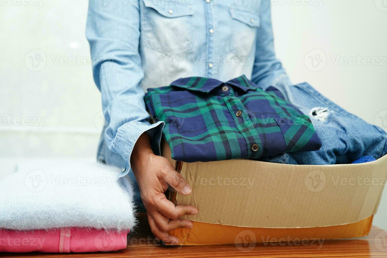 dons de vêtements dans une boîte en carton pour les bénévoles. photo