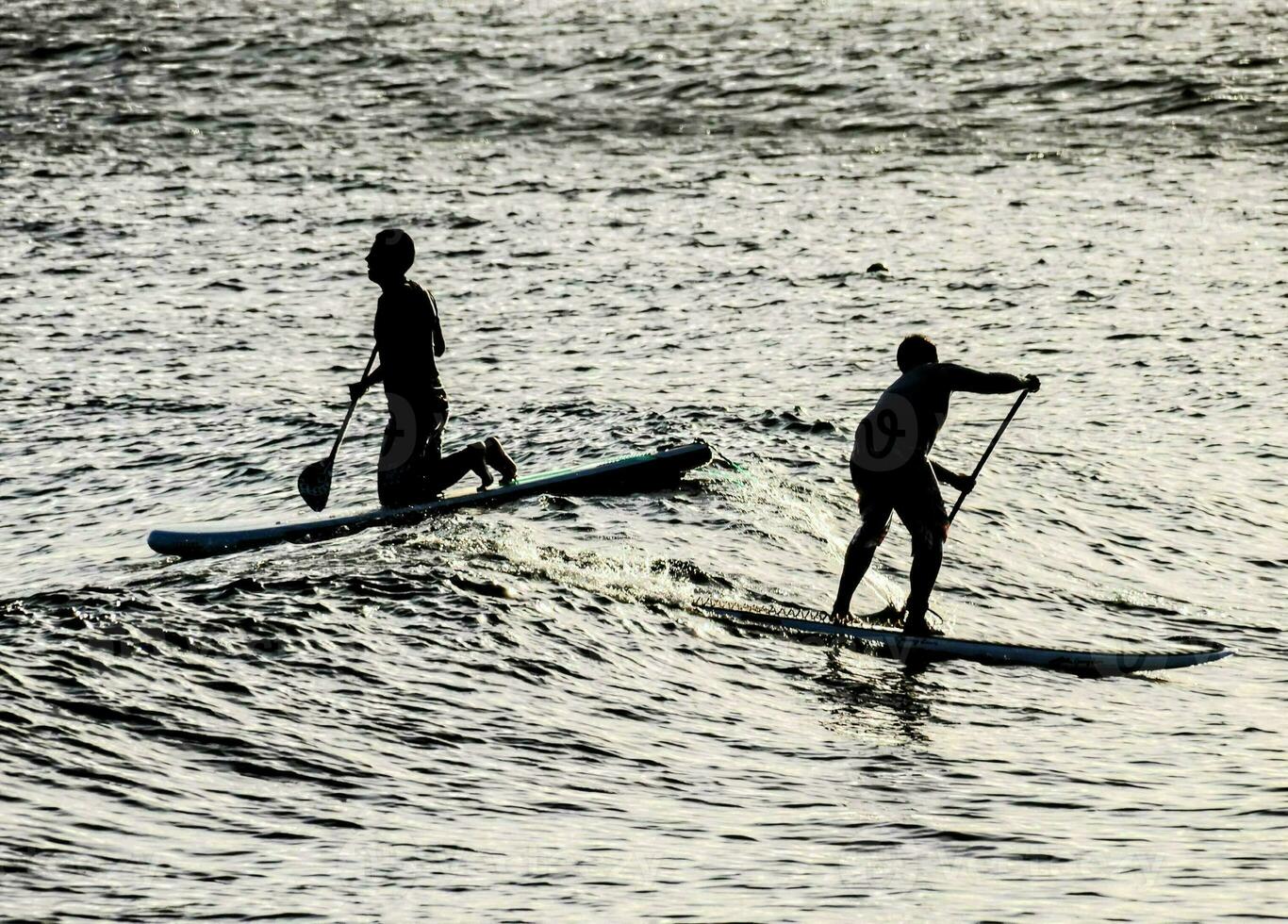 deux gens pagayer embarquement dans le océan photo