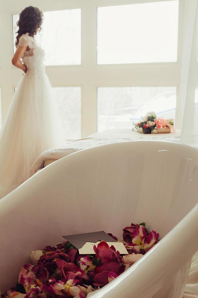 mariée avec baignoire remplie de fleurs photo