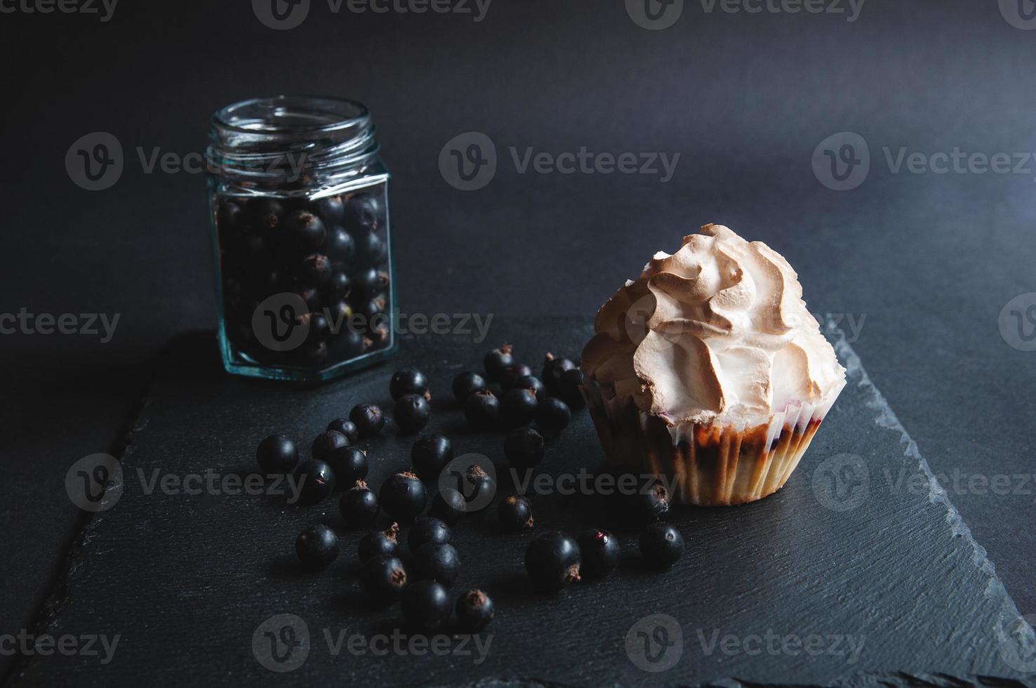 appétissant muffin à la vanille cuit au four avec des groseilles sur un tableau noir. photo