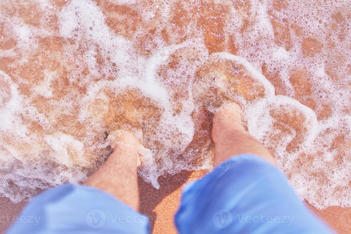 les pieds des hommes sur la plage photo