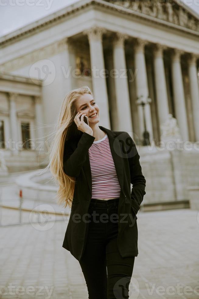 belle femme souriante utilisant un téléphone portable et marchant photo