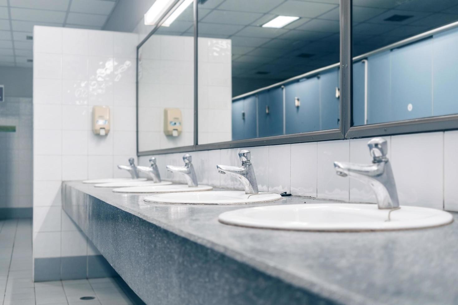 toilettes publiques et salle de bain intérieure avec lavabo et salle de toilette. photo