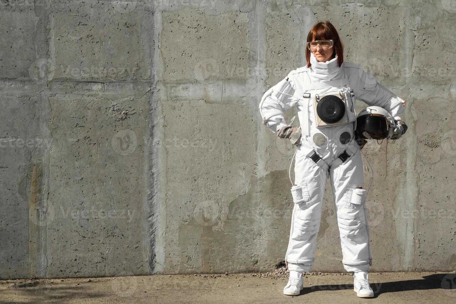 femme astronaute sans casque sur fond de mur gris photo