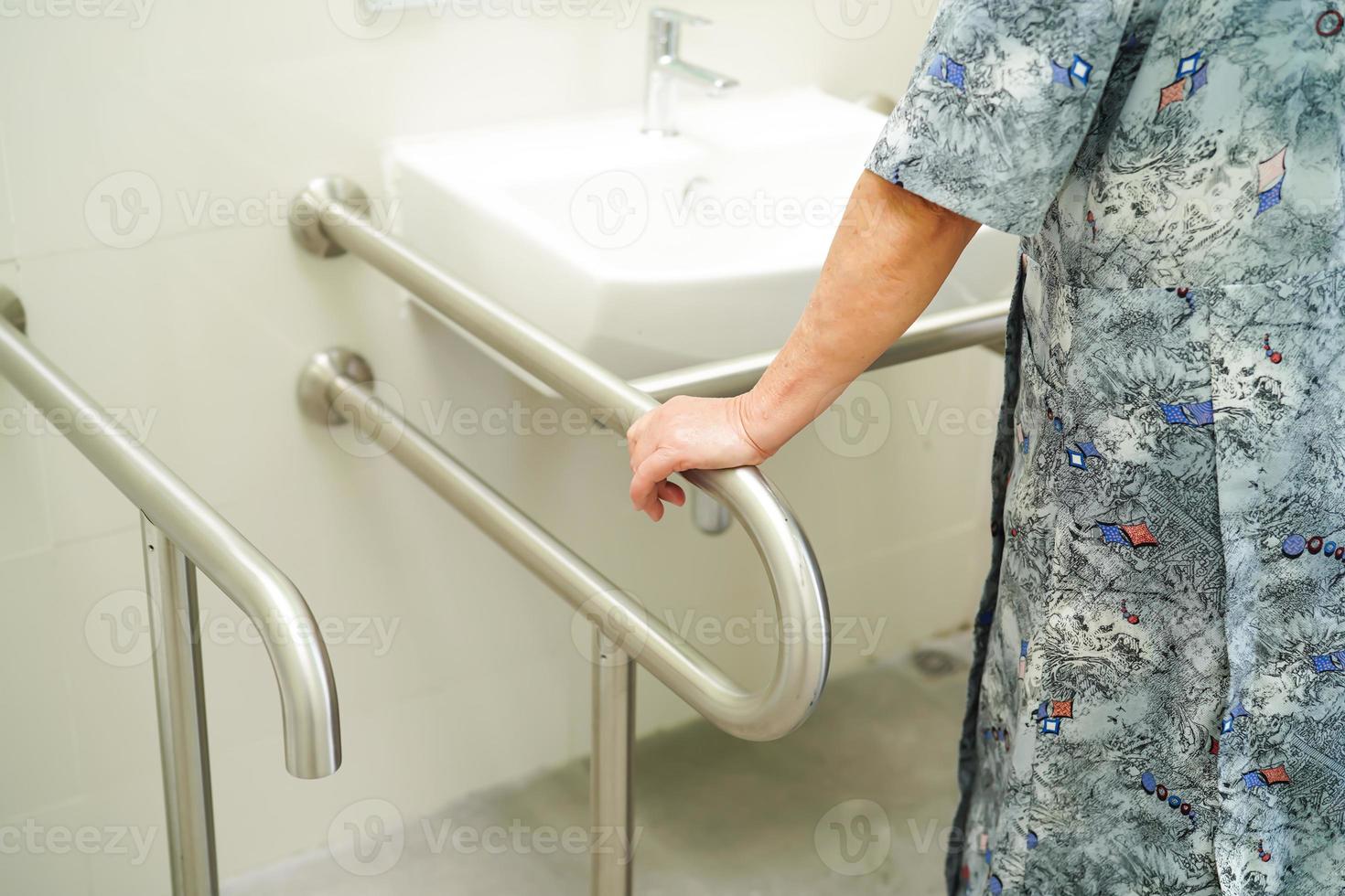 femme senior asiatique patient utiliser toilettes salle de bain poignée sécurité photo