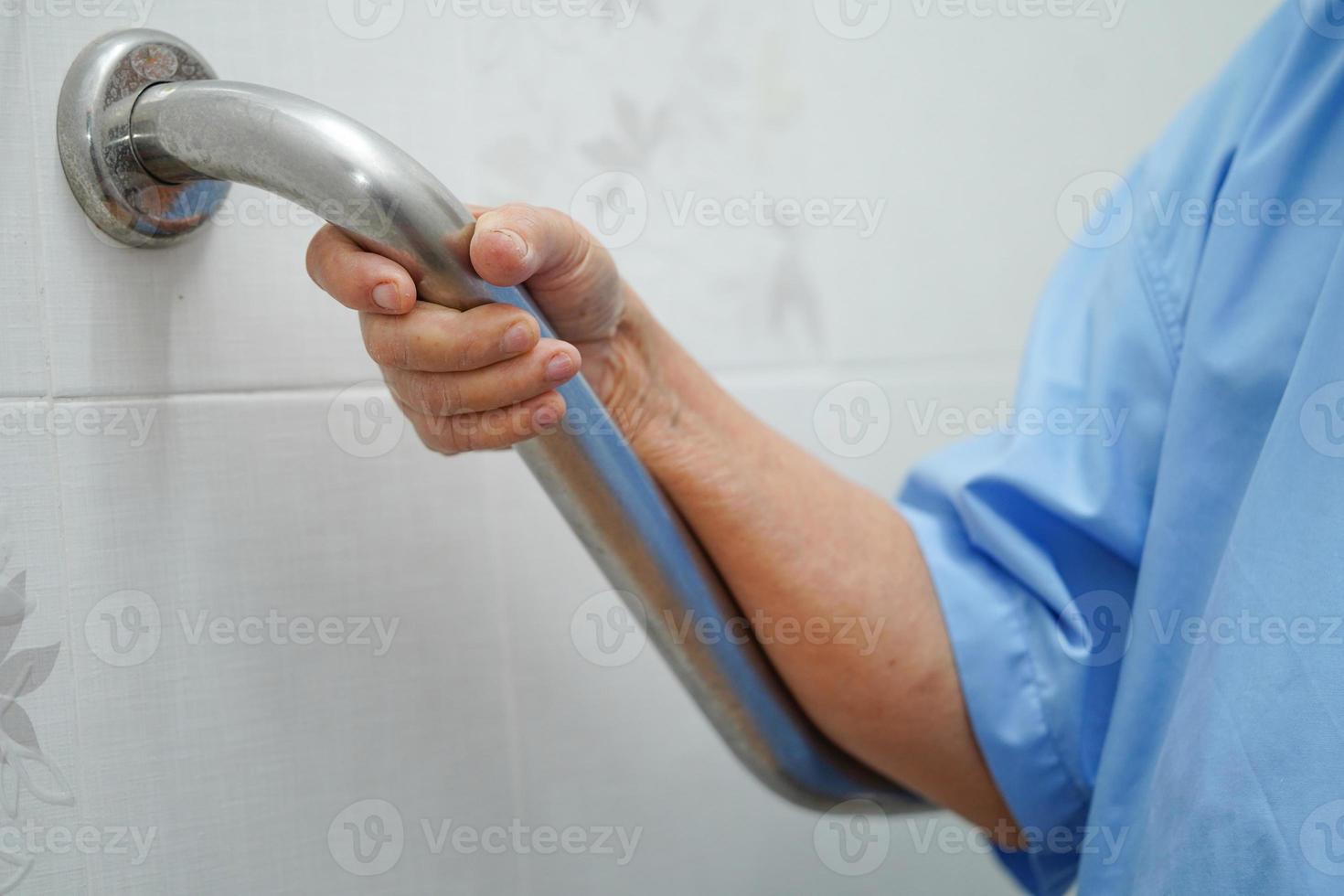 femme senior asiatique patient utiliser toilettes salle de bain poignée sécurité photo