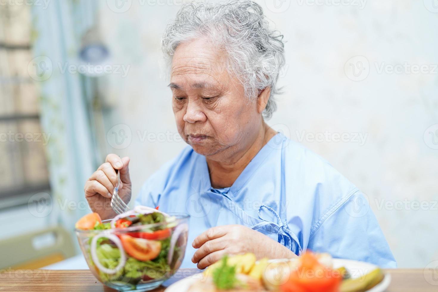 patiente asiatique âgée prenant son petit déjeuner à l'hôpital. photo