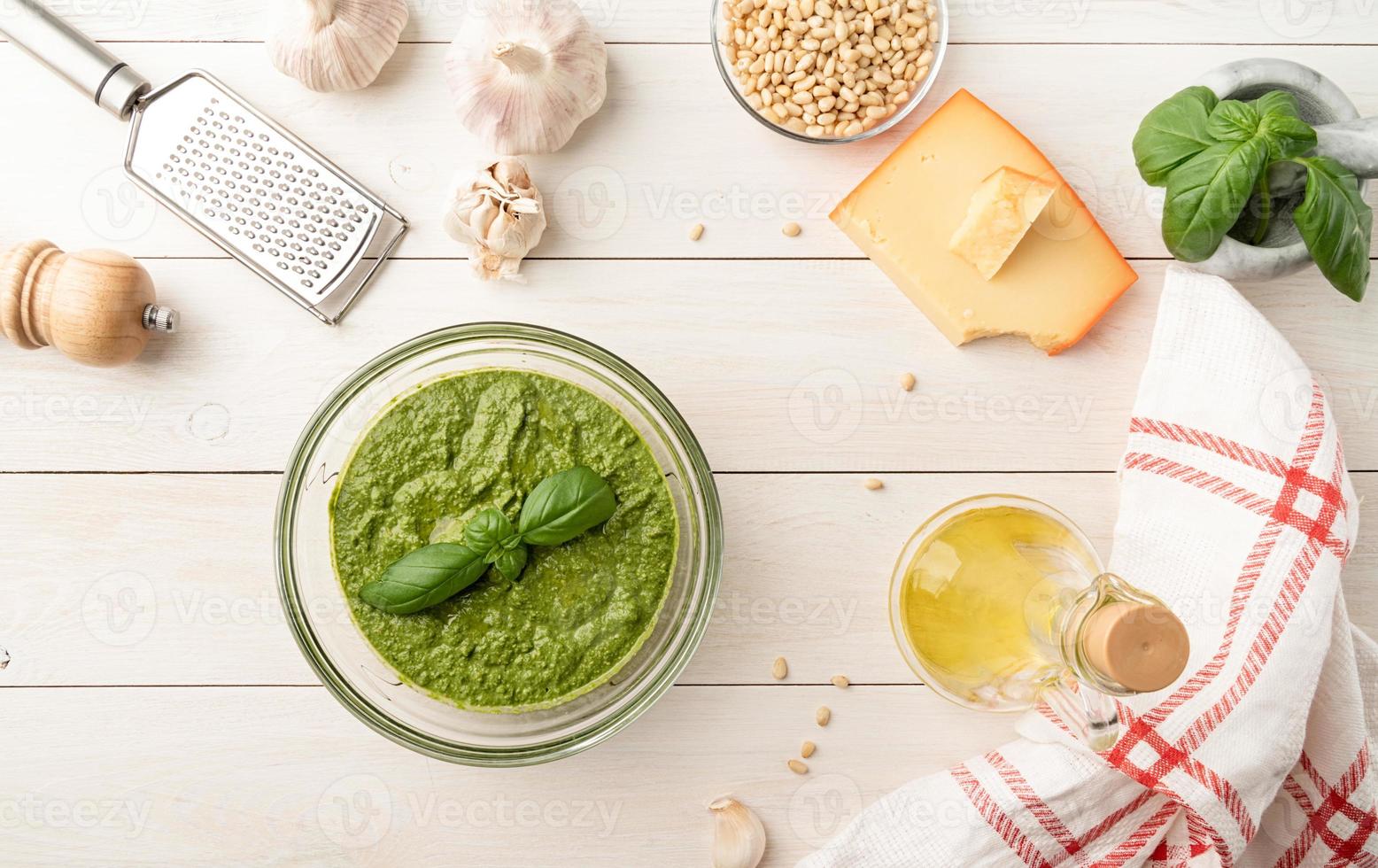 pesto frais dans un bol avec des ingrédients, vue de dessus à plat sur blanc photo