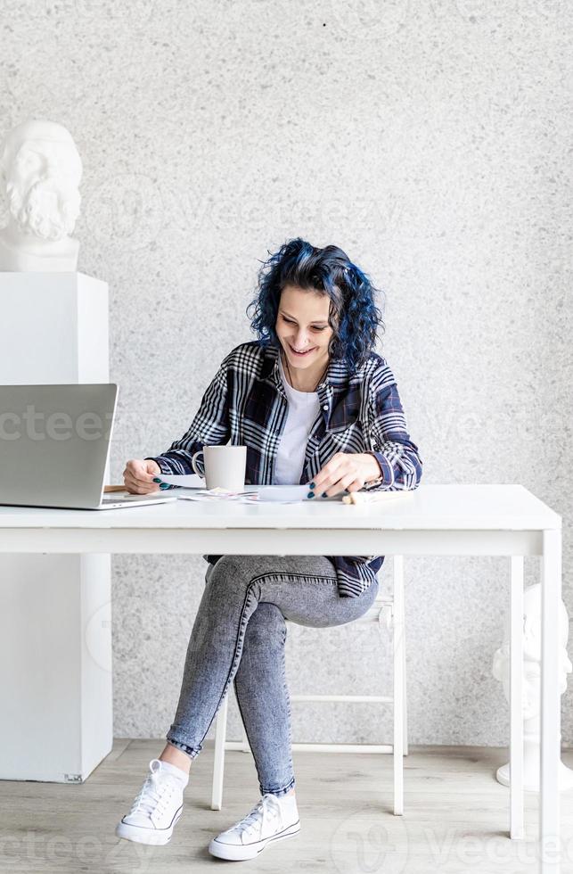 designer travaillant avec des palettes de couleurs et un ordinateur portable dans son studio photo