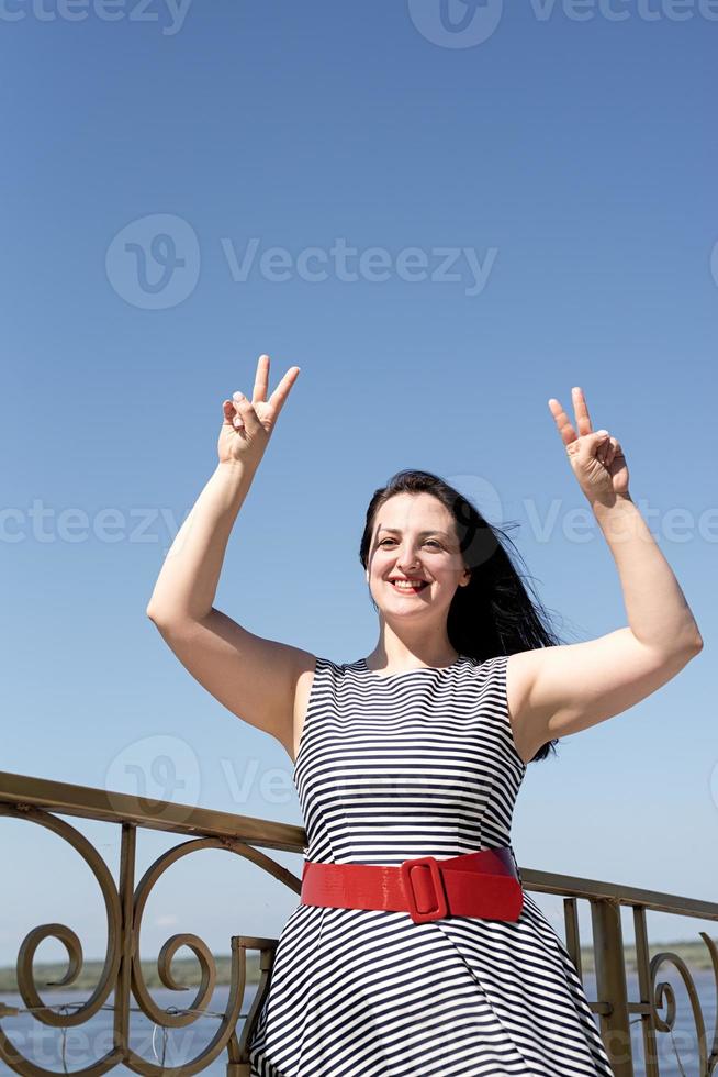 belle jeune femme a ouvert ses mains au ciel bleu photo