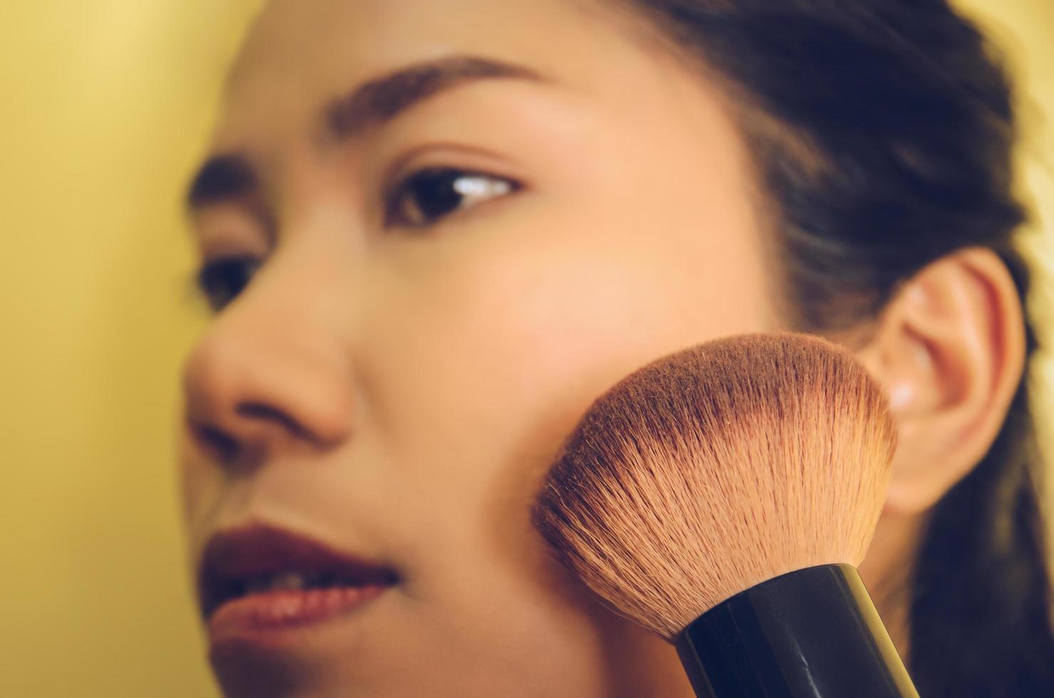 visage de beauté d'une femme asiatique en appliquant des pinceaux sur la peau par des cosmétiques. photo