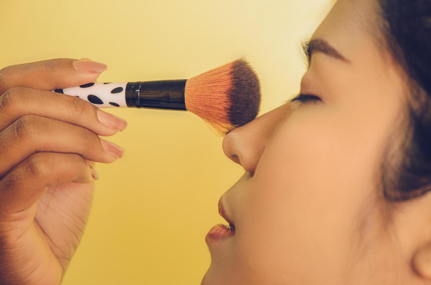 visage de beauté d'une femme asiatique en appliquant des pinceaux sur la peau par des cosmétiques. photo