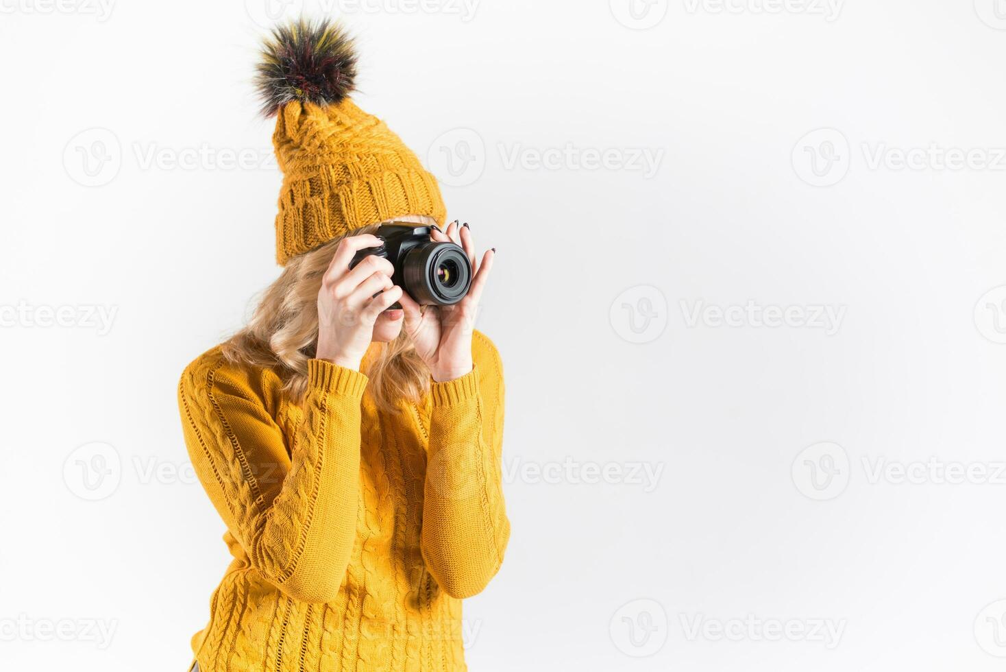 portrait de une magnifique fille photographe dans une tricoté chapeau qui prend des photos dans le studio