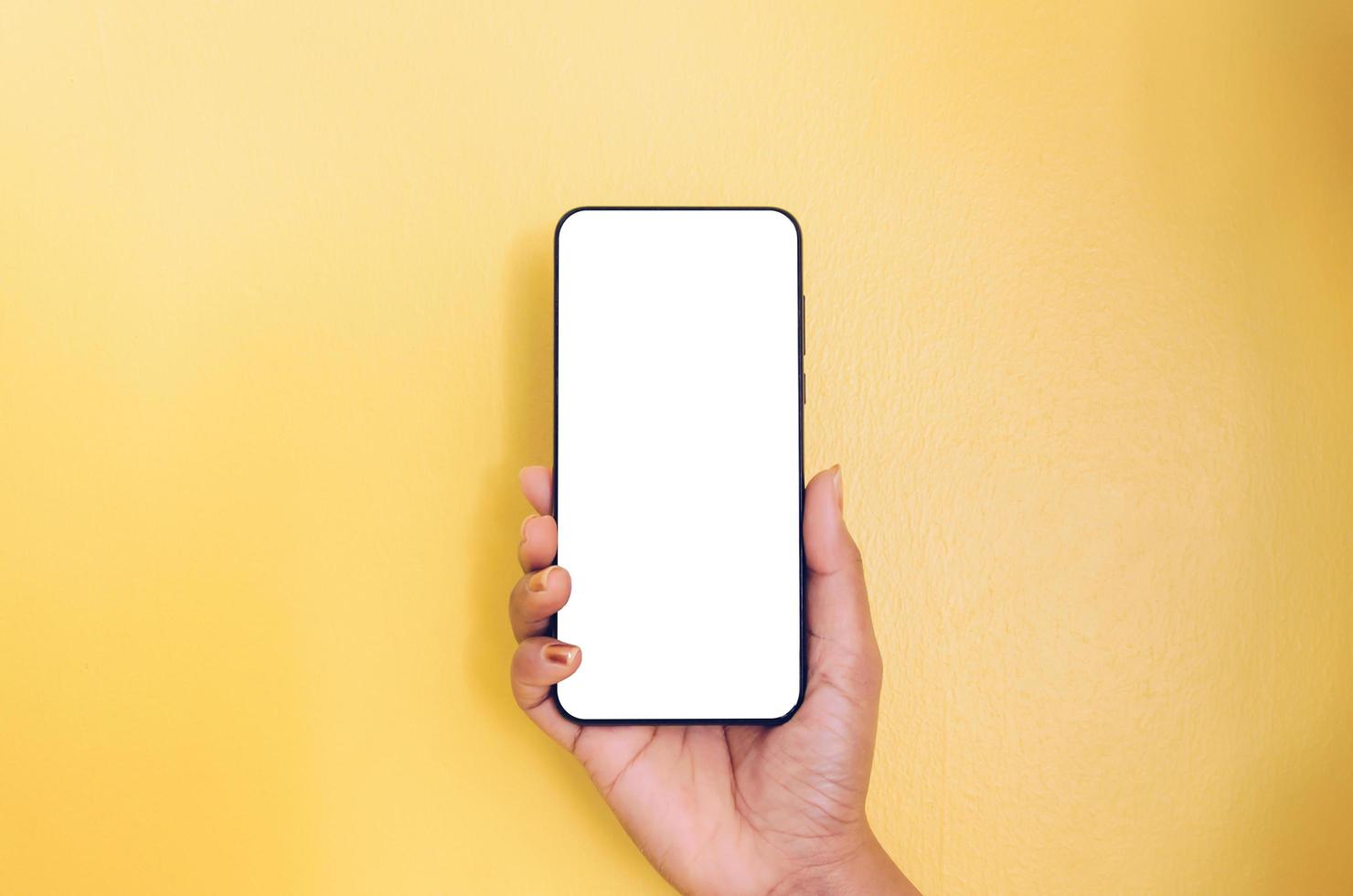 une main tenant un smartphone avec un fond d'écran blanc. photo