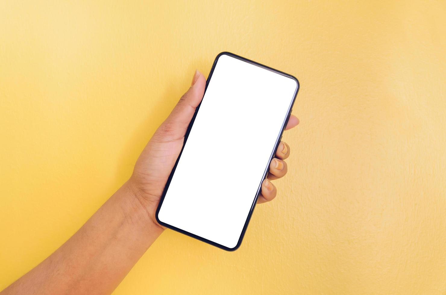 une main tenant un smartphone avec un fond d'écran blanc. photo