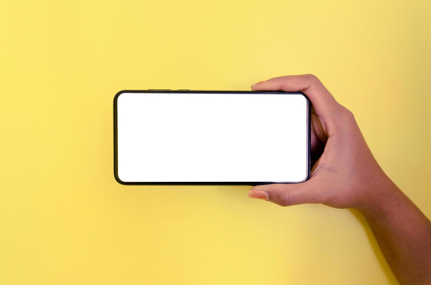 une main tenant un smartphone avec un fond d'écran blanc. photo