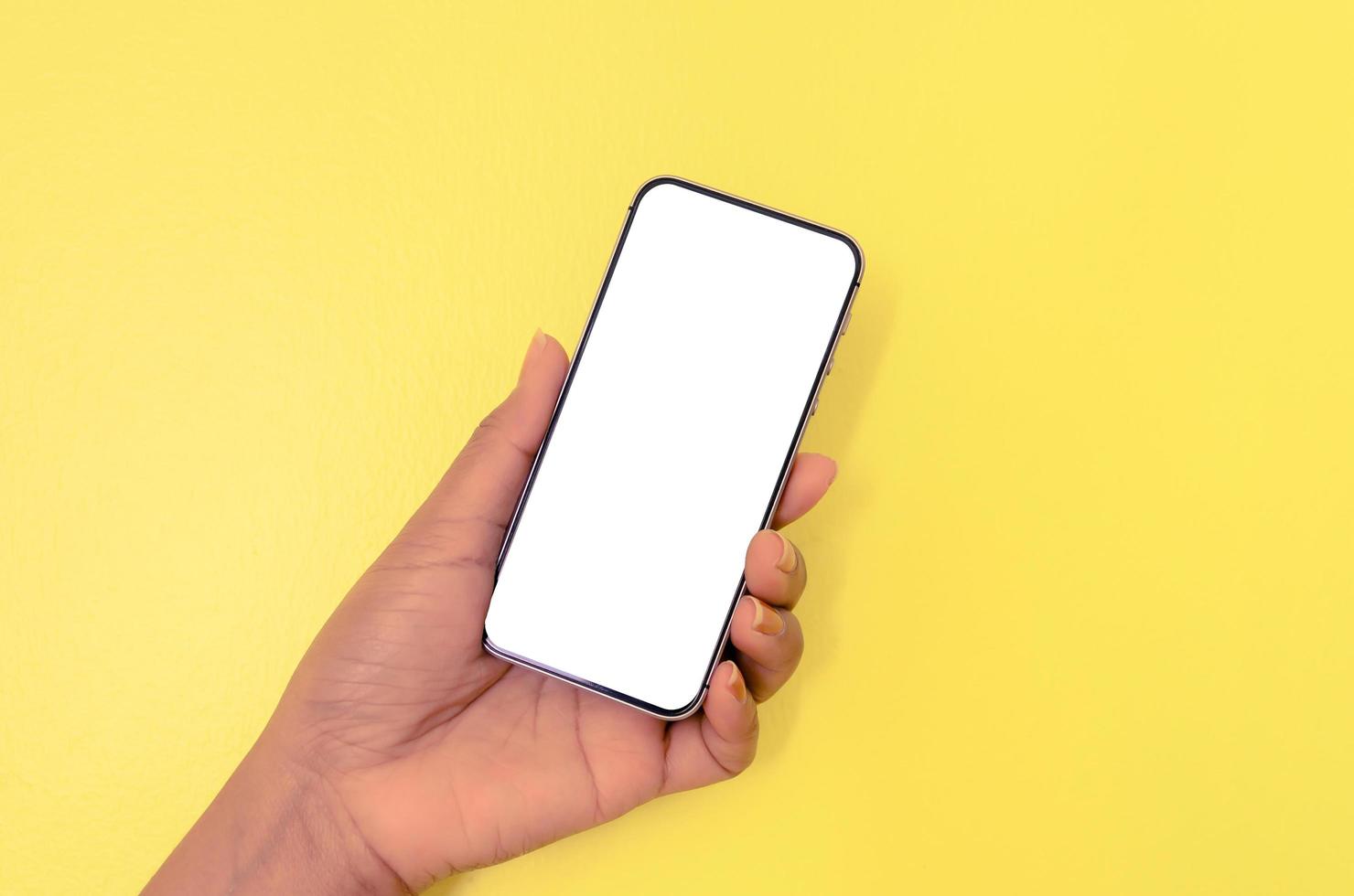 une main tenant un smartphone avec un fond d'écran blanc. photo