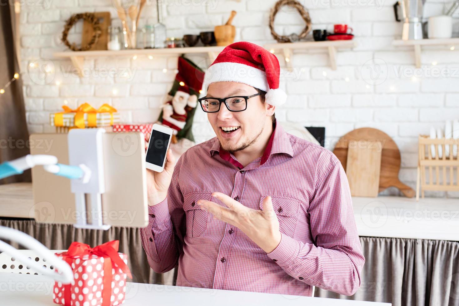 homme en bonnet de noel saluant ses amis en chat vidéo ou appel sur tablette photo