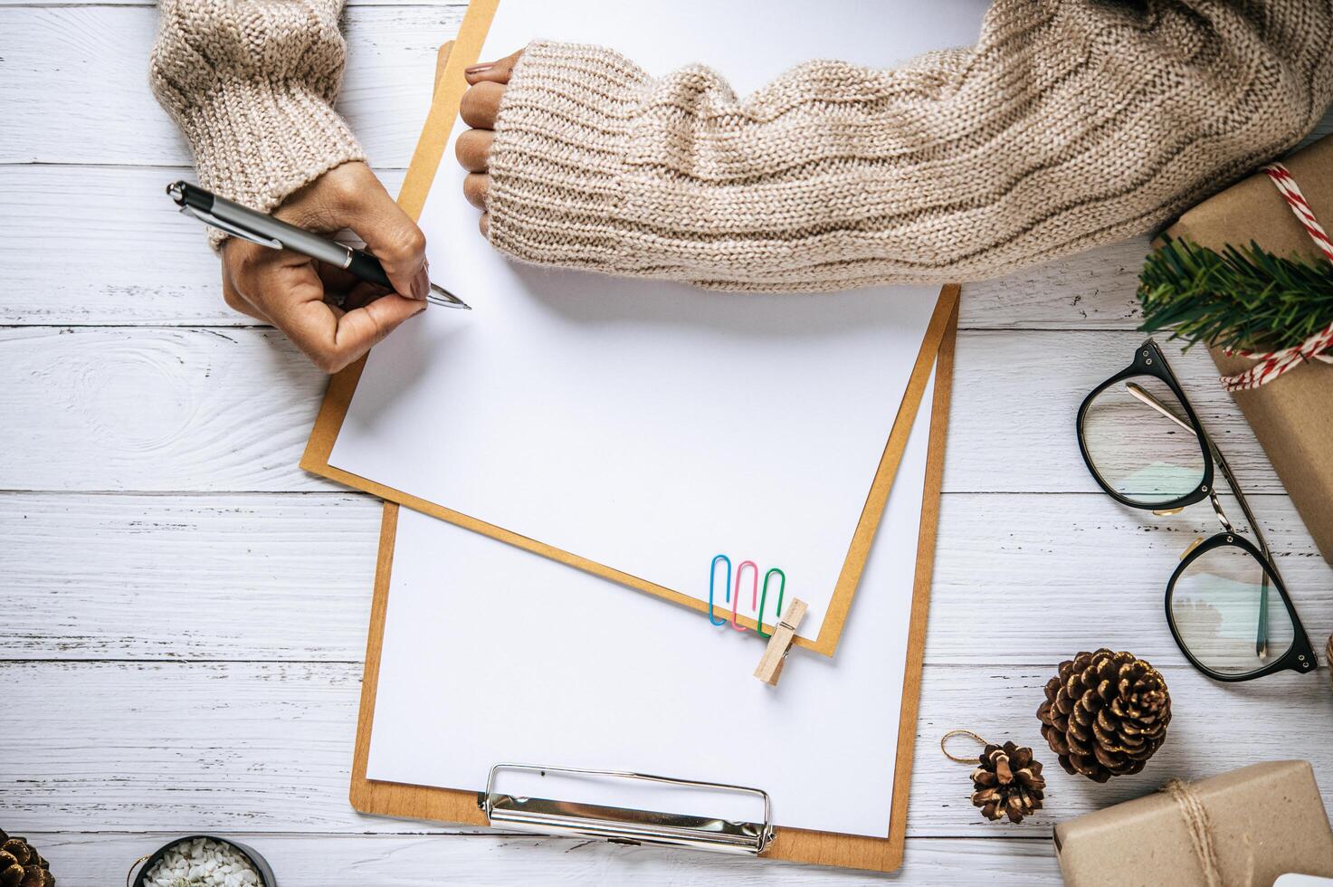 une main tenant un stylo pour écrire sur un presse-papiers photo