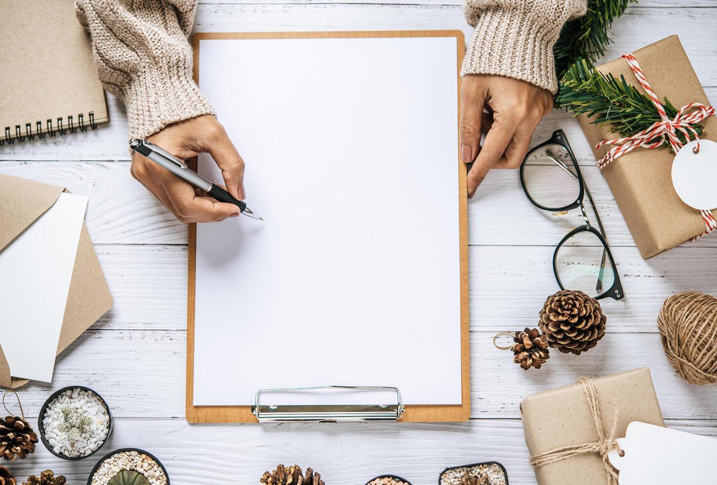 une main tenant un stylo pour écrire sur un presse-papiers photo