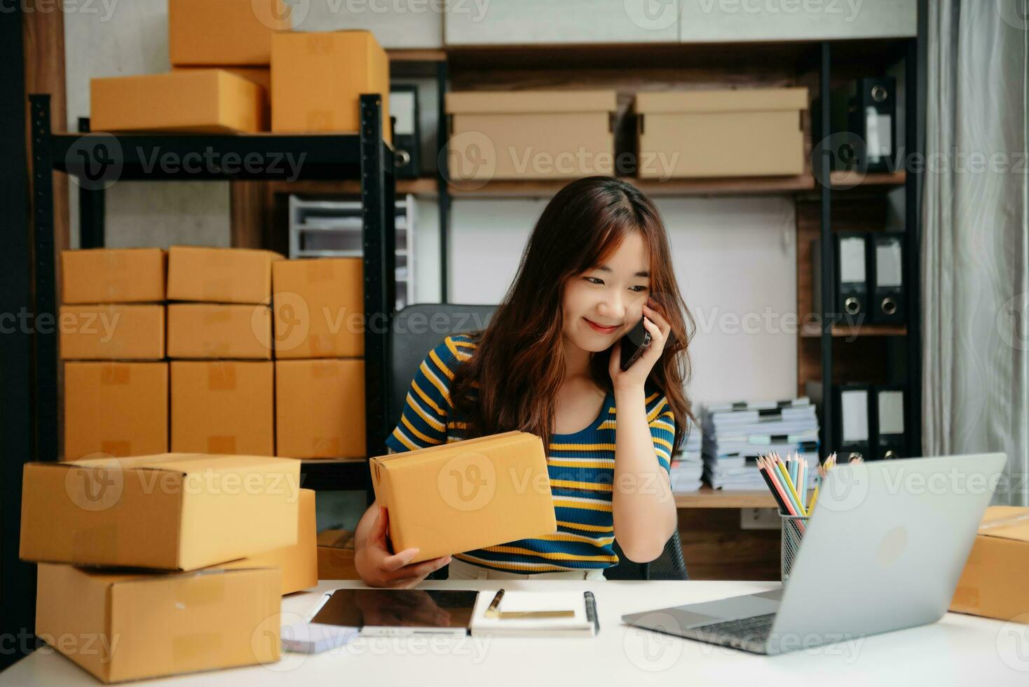 Jeune femme en portant une téléphone intelligent, tablette montrant Paiement Succès et crédit carte avec Jaune parcelle boîte comme en ligne achats concept photo