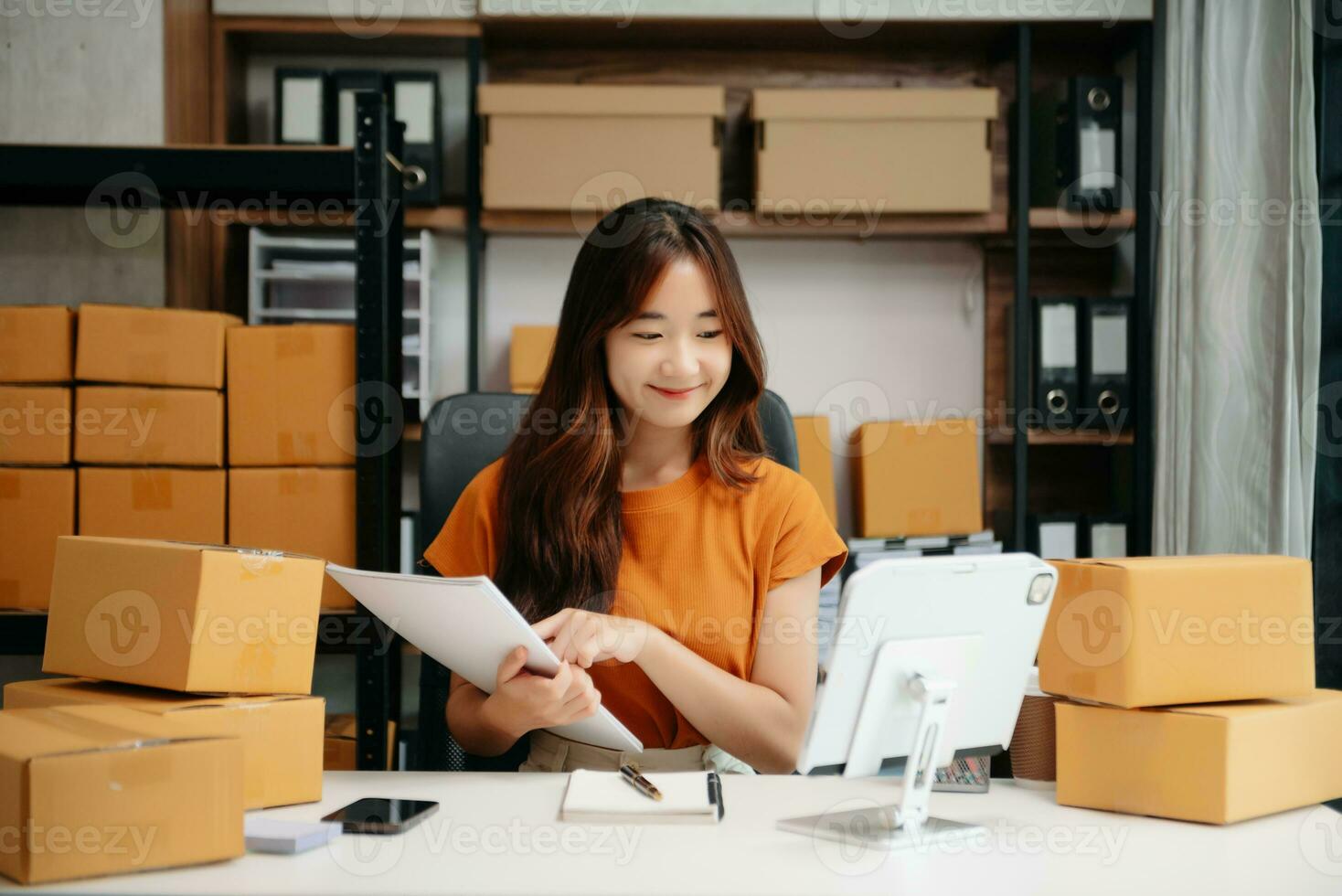 Jeune femme en portant une téléphone intelligent, tablette montrant Paiement Succès et crédit carte avec Jaune parcelle boîte comme en ligne achats concept photo