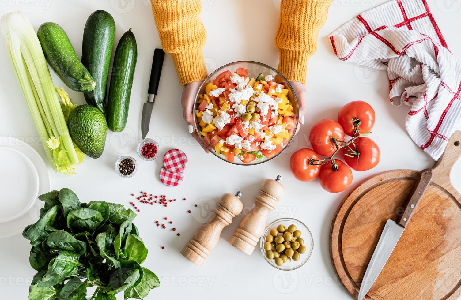 vue de dessus des mains féminines faisant de la salade grecque photo