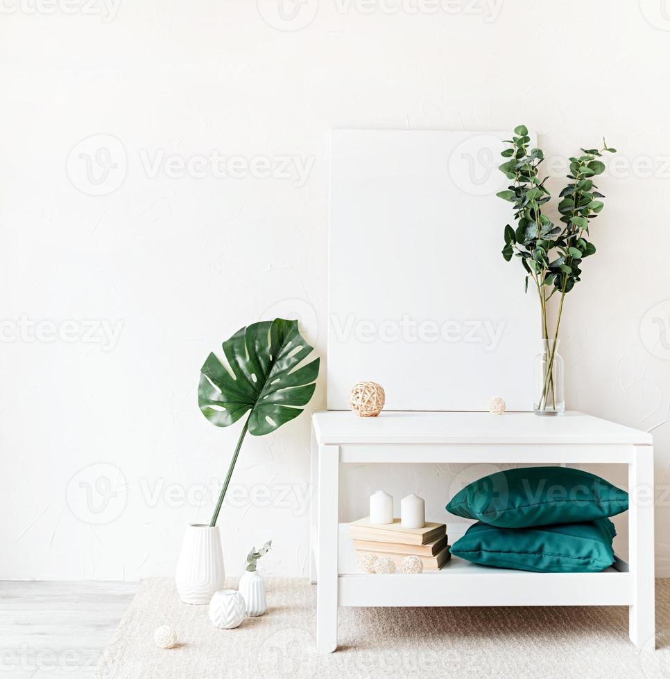 cadre d'affiche sur la table basse avec des décorations sur fond de mur blanc photo