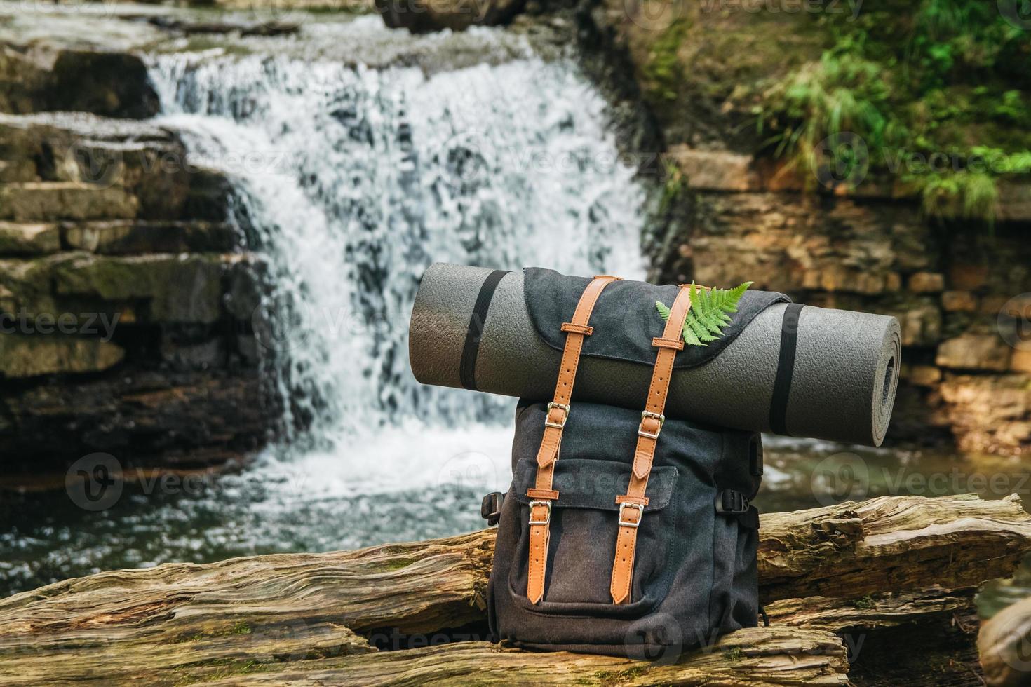sac à dos touristique hipster randonneur sur fond de rivière et cascade photo